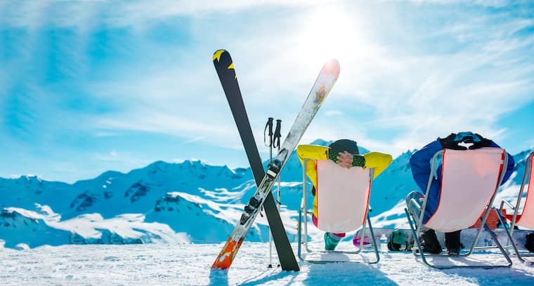 Un couple profite du paysage des montagnes sur une piste de skis.